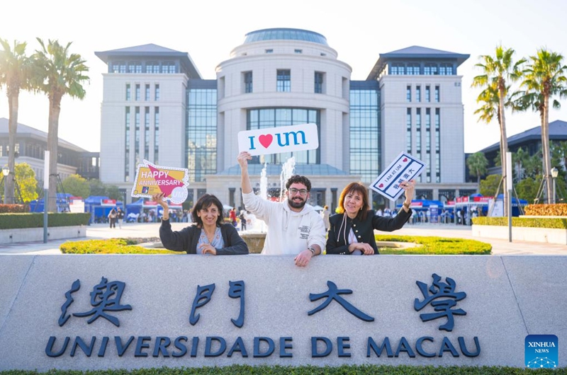 Foreigners pose for photos in front of the library of University of Macao in Macao, south China, Jan. 11, 2026. The launch ceremony for the celebrations of the 45th anniversary of the University of Macao, along with an open-day event, kicked off here on Sunday. (Xinhua/Cheong Kam Ka)