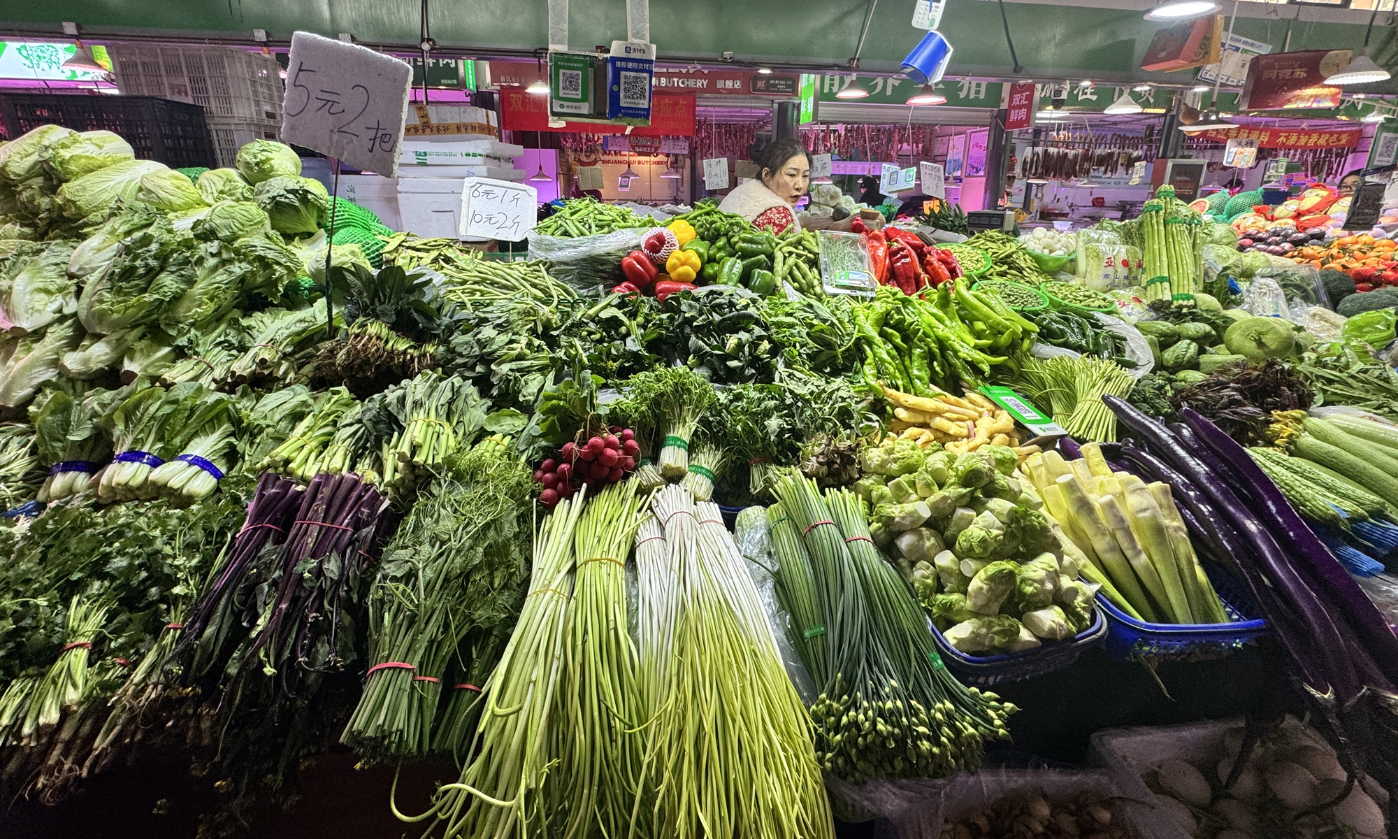 A vendor prepares a variety of fresh vegetables at a stall in a vegetable market in Chaoyang district, Beijing, on January 9, 2016. Ph0to: Shan Jie/GT