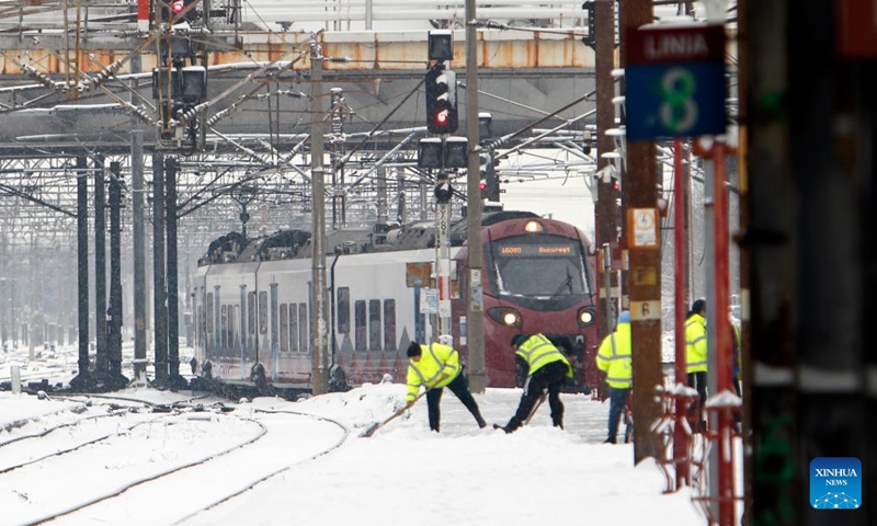Workers clear snow amid snowfall at North Railway station in Bucharest, Romania, on Jan. 11, 2026. Romania is facing a severe winter episode, with snowfall, blizzards, persistent frost and extremely low temperatures in large parts of the country. Photo: Xinhua