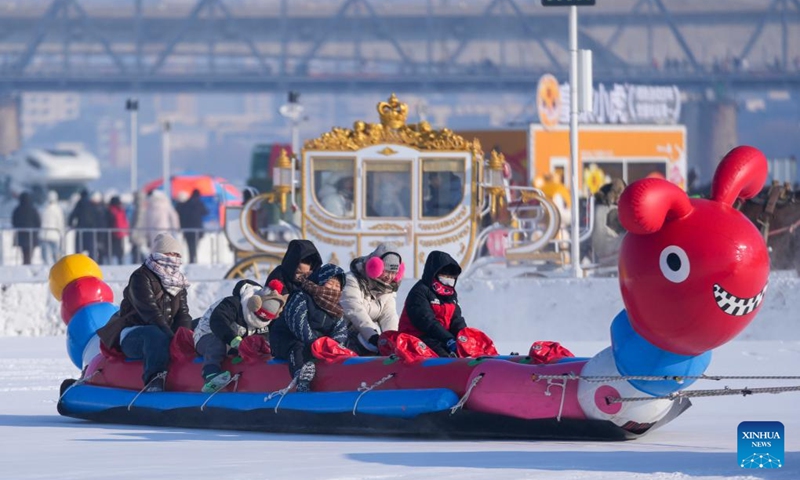 Tourists play on the frozen surface of the Songhua River in Harbin, northeast China's Heilongjiang Province, Jan. 11, 2026. The surface of the Harbin section of Songhua River, now solidly frozen, serves as a fun field, where locals and tourists alike enjoy themselves with ice-and-snow-themed amusements. (Xinhua/Wang Jianwei)