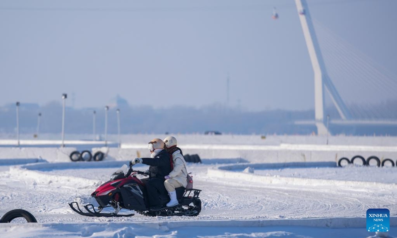 Tourists ride snow motorbike on the frozen surface of the Songhua River in Harbin, northeast China's Heilongjiang Province, Jan. 11, 2026. The surface of the Harbin section of Songhua River, now solidly frozen, serves as a fun field, where locals and tourists alike enjoy themselves with ice-and-snow-themed amusements. (Xinhua/Wang Jianwei)