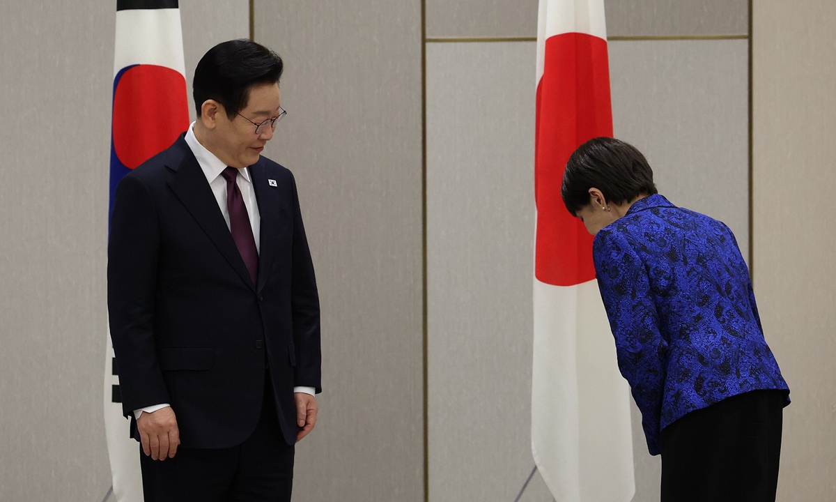 Japanese Prime Minister Sanae Takaichi bows to national flags next to South Korean President Lee Jae-myung at the start of their meeting in Nara, Japan on January 13, 2026. Photo: VCG