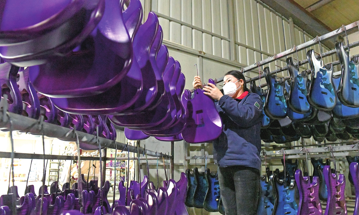 A worker inspects an electric guitar body at a musical instrument manufacturing company in Huainan,East China's Anhui Province on January 14, 2026. The company specializes in producing electric guitars, electric bass instruments, and other stringed instruments for export to overseas markets. Photo: VCG