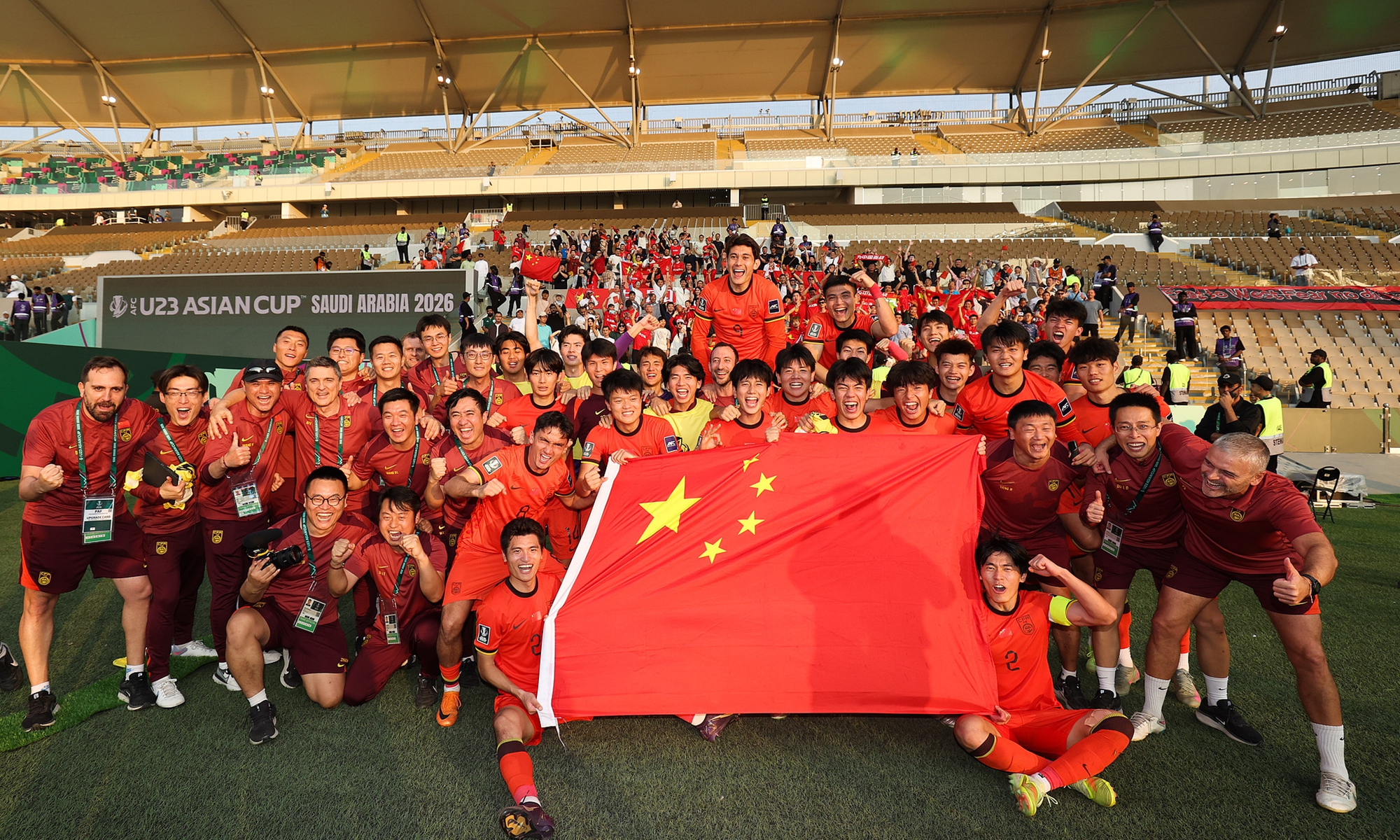 Chinese players and officials pose with the national flag after reaching the U23 Asian Cup semifinals on January 17, 2026. Photo: VCG