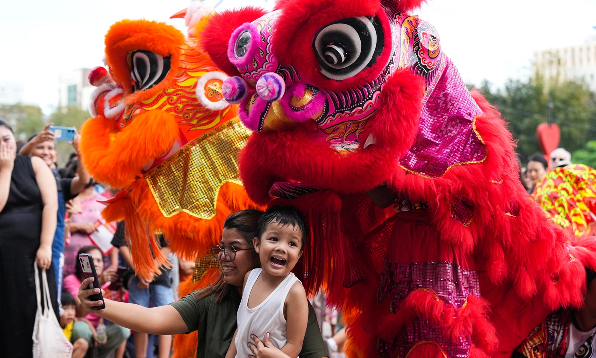 Philippine residents take photos with Chinese lion dancers at the 20th Philippines-China Traditional Culture Festival held on February 18, 2024. Photo: VCG