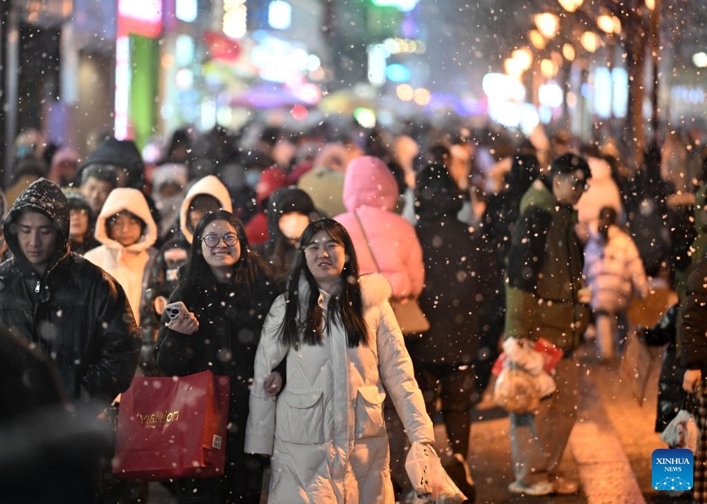 People walk amid snowfall on a street in Heping District of Tianjin, north China, Jan. 17, 2026. Tianjin witnessed its first snowfall of 2026 on Saturday. (Photo: Xinhua)