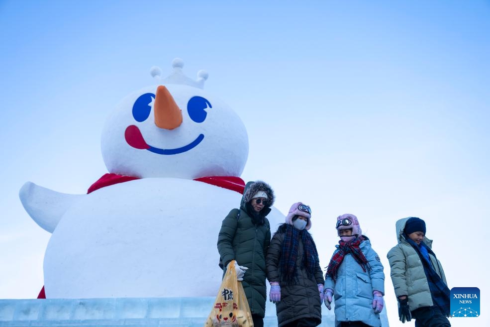 Tourists pose for photos with a giant snowman at Jingyang square in Harbin, northeast China's Heilongjiang Province, Jan. 1, 2026. With the arrival of the ice and snow season, various public facilities in Heilongjiang Province have created distinctive snowman-themed landscapes to attract locals and tourists. (Photo: Xinhua)