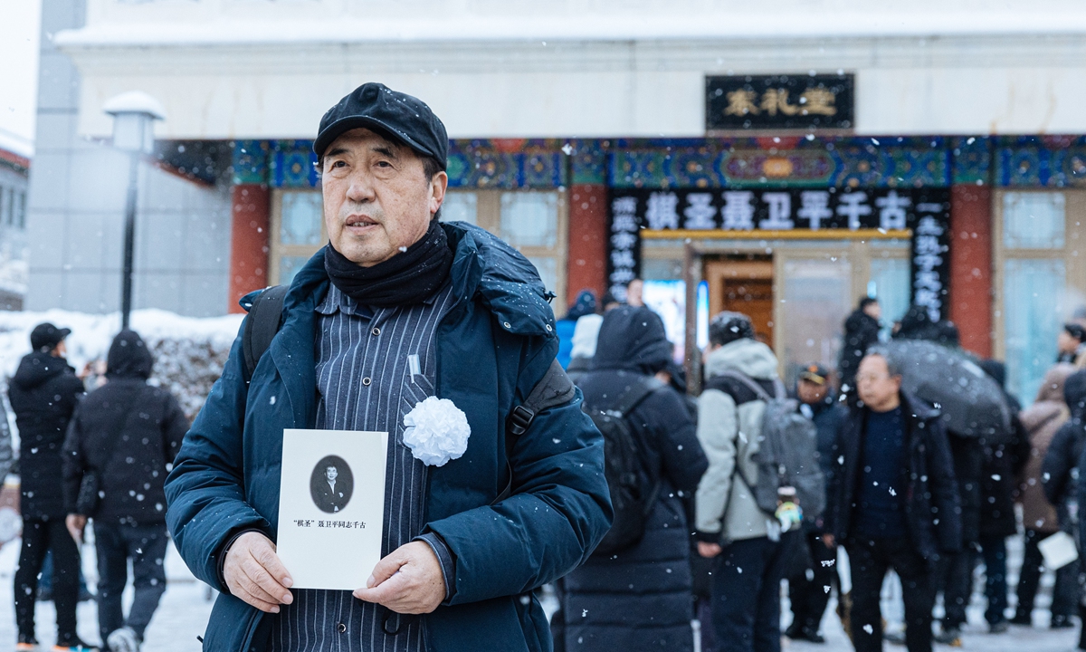 A mourner holds a memorial leaflet of Nie Weiping in snow at the Babaoshan Funeral Home in Beijing on January 18, 2026. Photo: Li Hao/GT