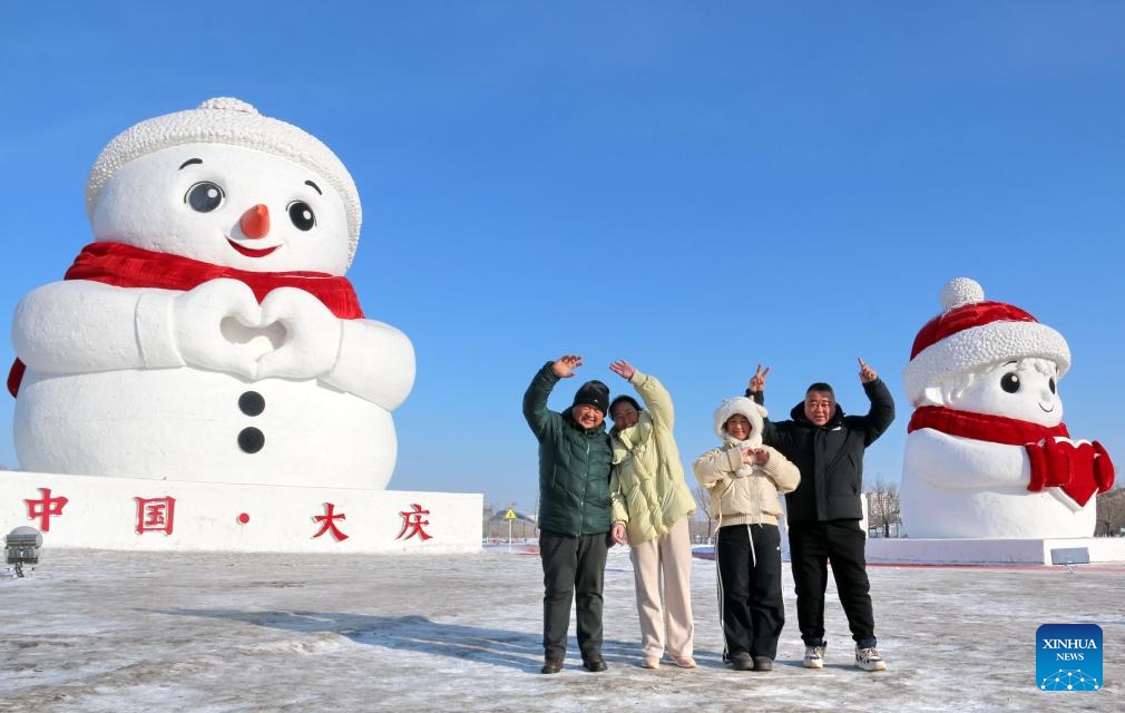 Tourists pose for photos with giant snowmen in Daqing City, northeast China's Heilongjiang Province, Jan. 16, 2026. With the arrival of the ice and snow season, various public facilities in Heilongjiang Province have created distinctive snowman-themed landscapes to attract locals and tourists. (Photo: Xinhua)
