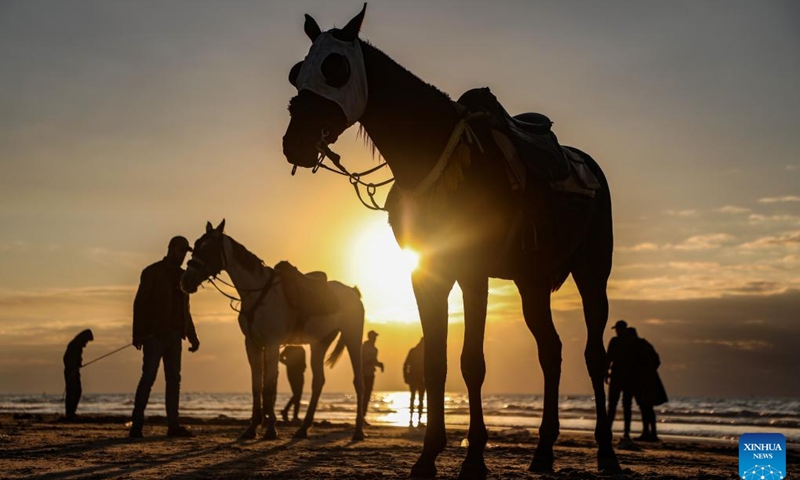 Palestinians spend time on a beach in Gaza City at sunset, Jan. 16, 2026. (Photo: Xinhua)