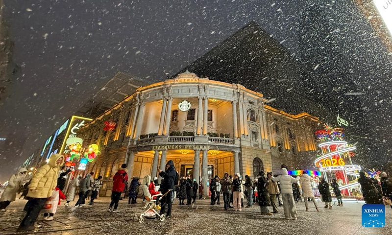 People walk amid snowfall on a street in Heping District of Tianjin, north China, Jan. 17, 2026. Tianjin witnessed its first snowfall of 2026 on Saturday. (Photo: Xinhua)