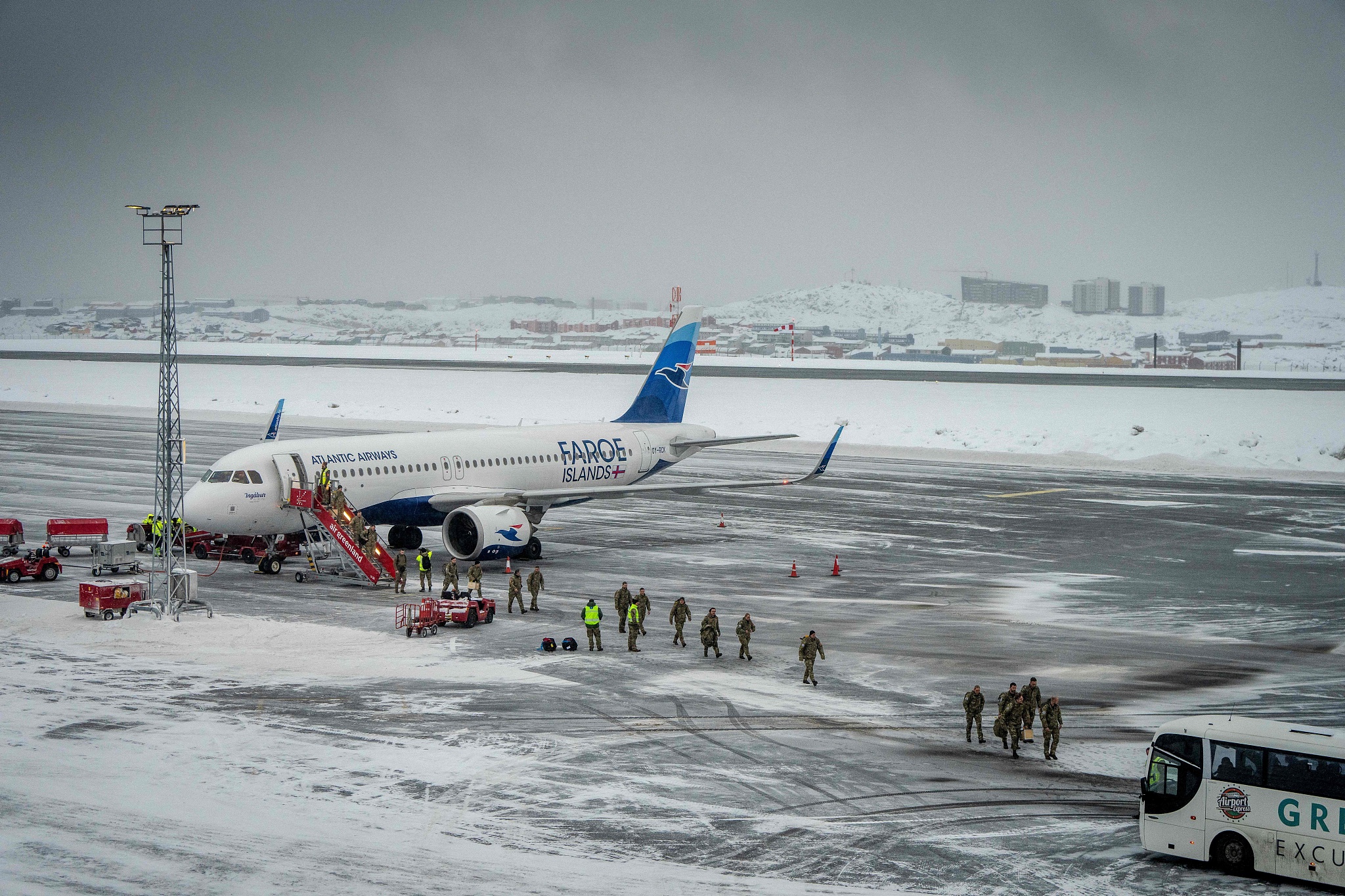 Danish soldiers walk across the frozen tarmac after arriving at Nuuk airport, Greenland, on January 19, 2026. The Danish Defense will continue its increased presence with exercise activities together with a number of NATO allies in and around Greenland in 2026. Photo: VCG