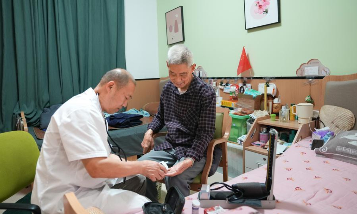 A doctor conducts medical examination for a senior resident (R) at a comprehensive elderly care center in Yingmenkou subdistrict of Chengdu, southwest China's Sichuan Province, Sept. 1, 2025. (Xinhua/Jiang Hongjing)
