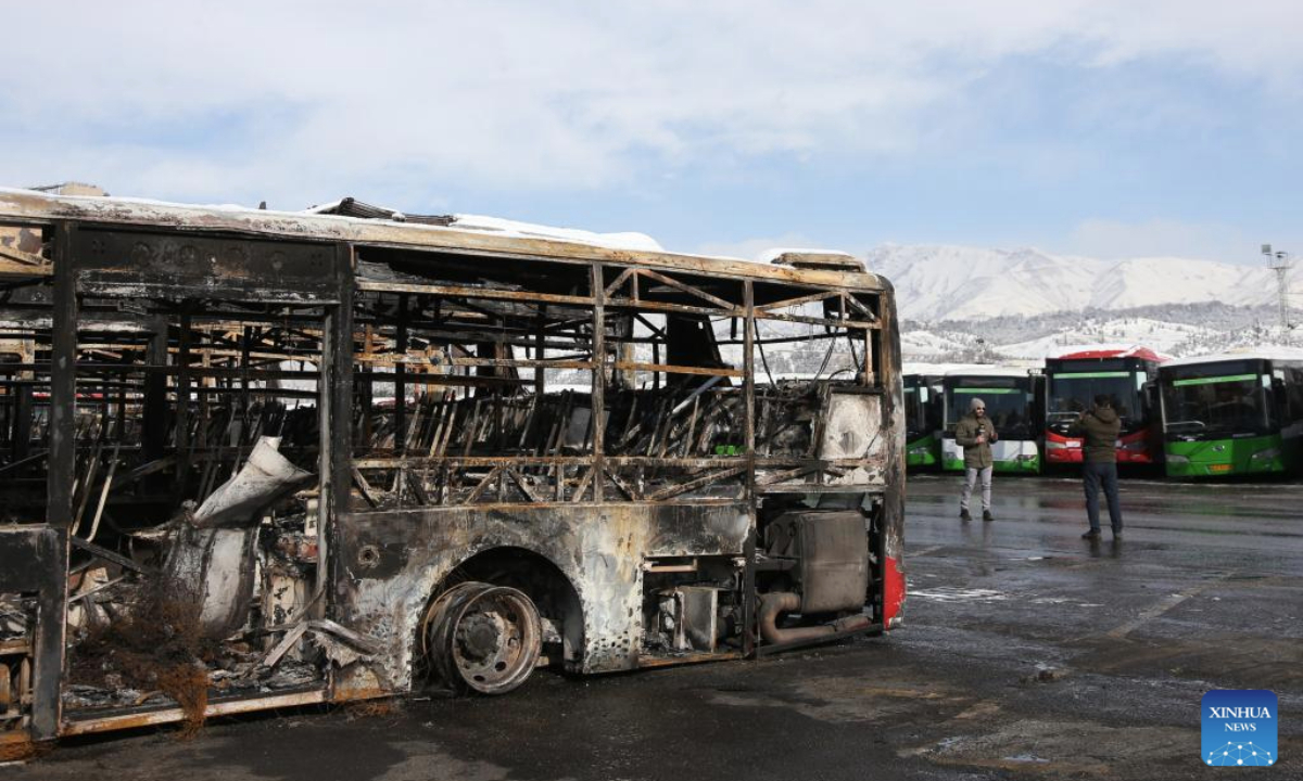 Media reporters make a report beside of a destroyed bus during recent unrest in Tehran, Iran, Jan. 21, 2026. Iran's state television IRIB reported on Wednesday that 3,117 people were killed during recent unrest, citing the country's Forensic Medical Organization. (Xinhua/Shadati)
