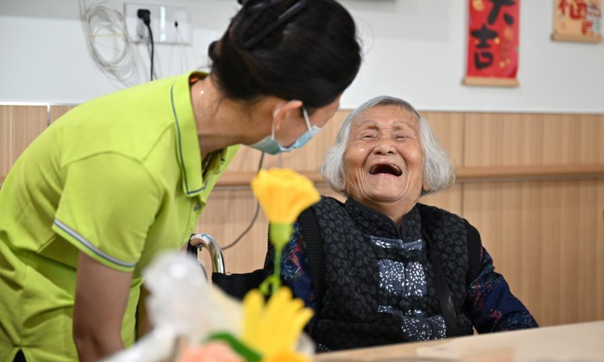 An elderly person chats with a staff worker at an elderly care service center in Qiongshan District of Haikou, south China's Hainan Province, Oct. 29, 2025. (Xinhua/Guo Cheng)