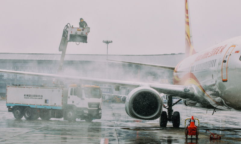 A worker clears snow from a passenger aircraft to provide a safe journey and maintain smooth and orderly flight operations at Hangzhou Xiaoshan International Airport in Hangzhou, East China's Zhejiang Province, on January 20, 2026. A broad swathe of central and eastern China braced for severe winter weather from Sunday to Wednesday, meteorological authorities said. Photo: VCG