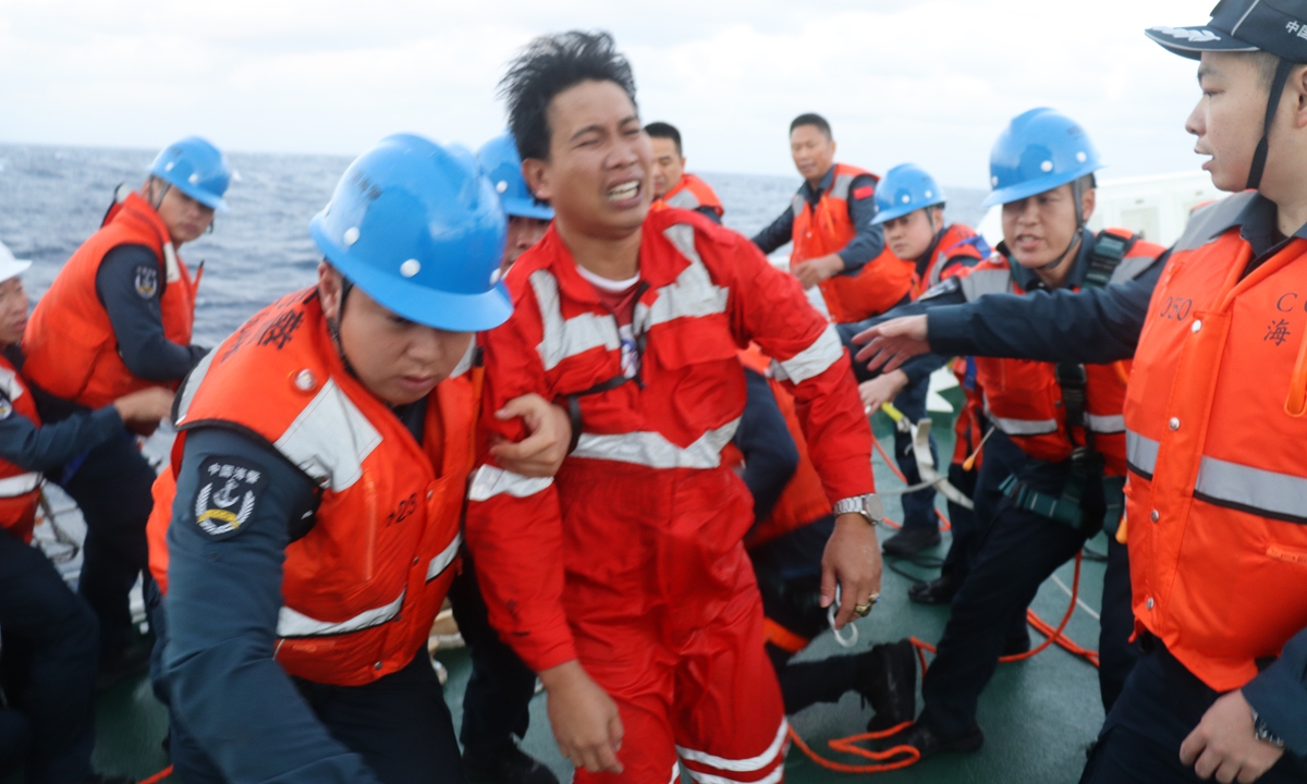 A photo provided to the Global Times from the China Coast Guard (CCG) shows CCG personnel assisting a rescued Filipino crew member of a capsized foreign cargo ship near the Huangyan Dao in the South China Sea on January 23, 2026. The ship was carrying 21 Philippine crew members, with 17 people rescued as of 12:30 pm on the day. Photo: Courtesy of CCG