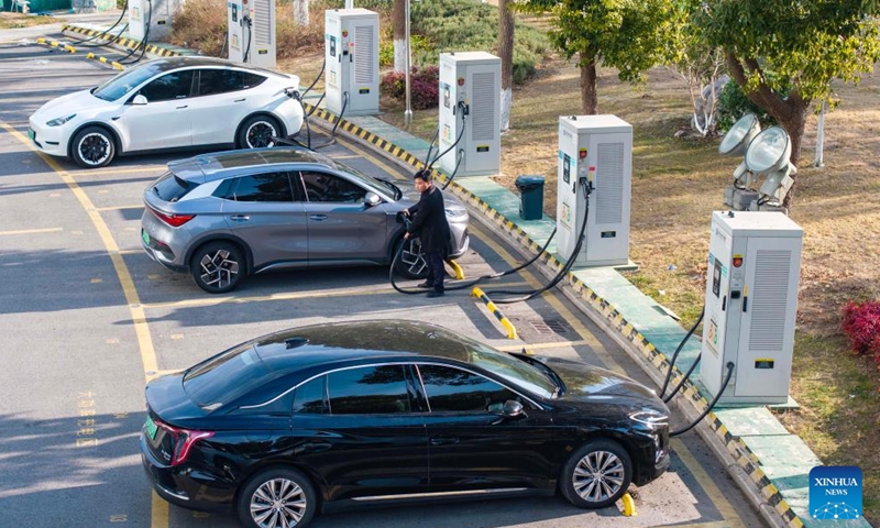 A drone photo taken on Jan. 22, 2026 shows a driver charging an electric vehicle in Taizhou, east China's Jiangsu Province. China has built the world's largest electric vehicle (EV) charging network, which can meet the charging demand of more than 40 million new energy vehicles, the National Energy Administration (NEA) said on Wednesday. (Photo by Tang Dehong/Xinhua)


