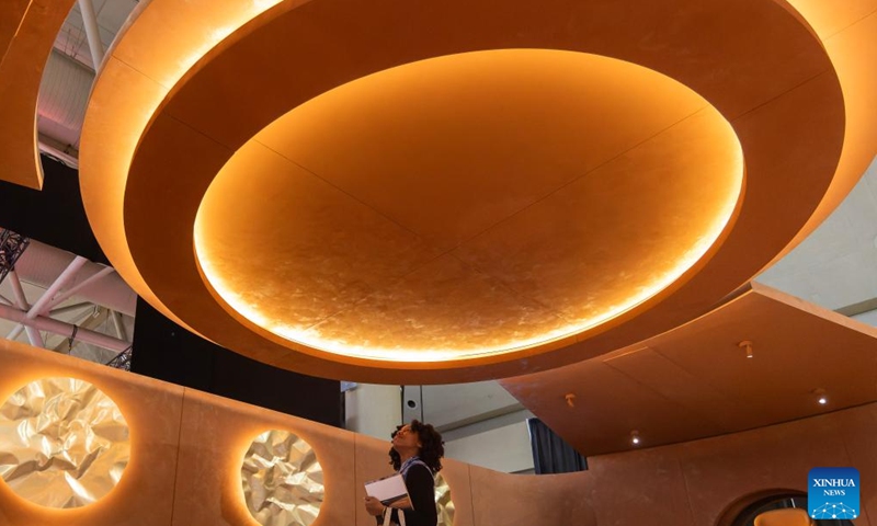 A woman looks up at a ceiling light during the Interior Design Show in Toronto, Canada, Jan. 22, 2026. The annual event kicked off here on Thursday and will run until Jan. 25. (Photo by Zou Zheng/Xinhua)

