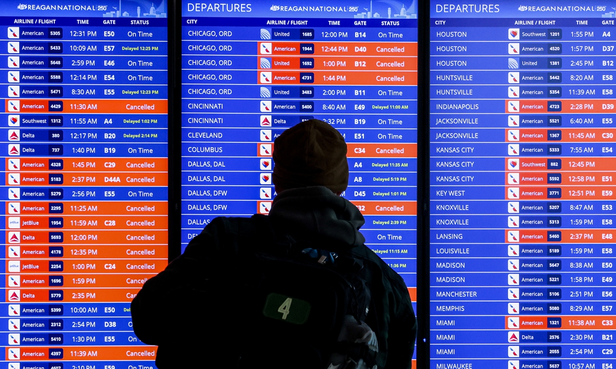 A traveler looks at a flight information board at Ronald Reagan Washington National Airport (DCA) in Arlington, Virginia, US, on January 26 local time, 2026. Travelers are bracing for extended disruptions to start the working week in the US as airlines try to get their schedules back on track following an intense winter storm that saw the most flight cancelations since the COVID-19 pandemic. Photo: VCG