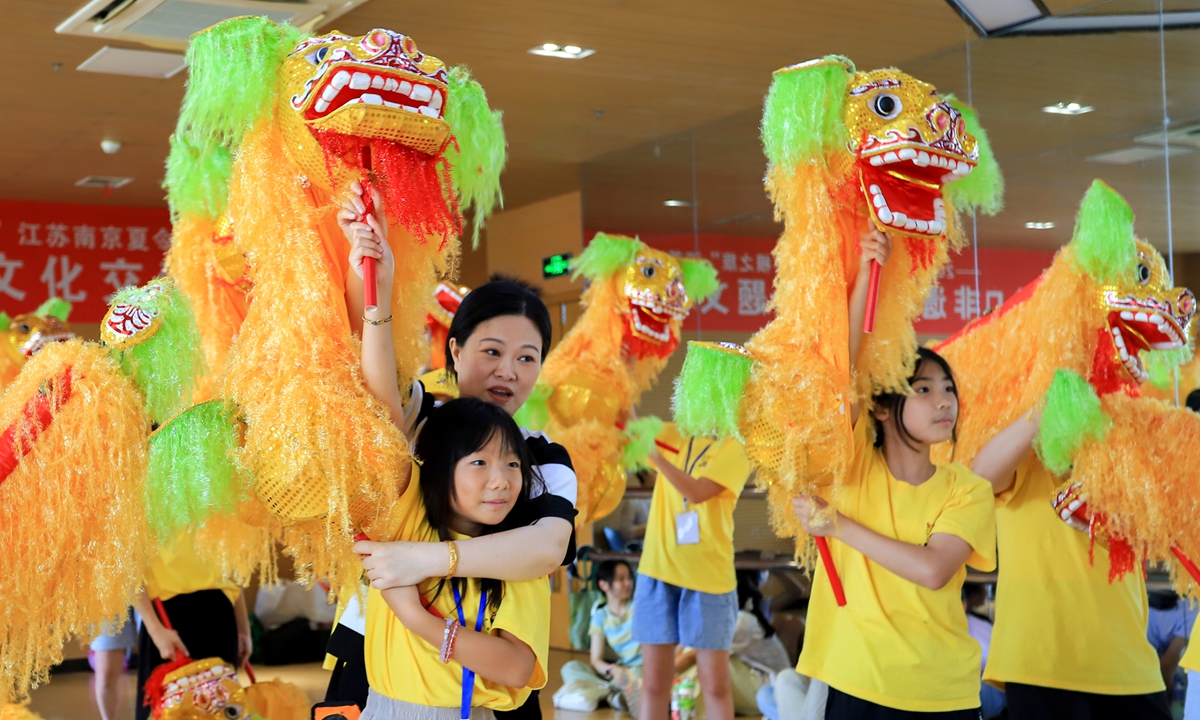 Descendants of overseas Chinese visiting China for a root-seeking journey try their hand at the Hand Lion Dance at an intangible cultural heritage exchange activity in Nanjing, Jiangsu Province, on July 20, 2025. Photo: IC