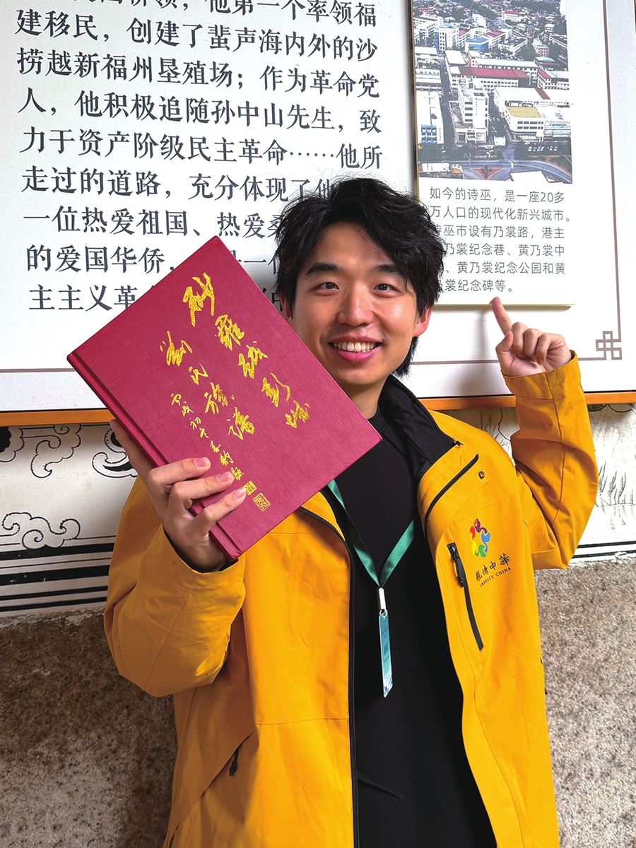 Malaysian youth Richard Lau Lee Siong takes photos holding his family tree at a museum with an overseas Chinese theme in Fuzhou, Fujian Province, on December 23, 2025. Photo: Courtesy of Lau