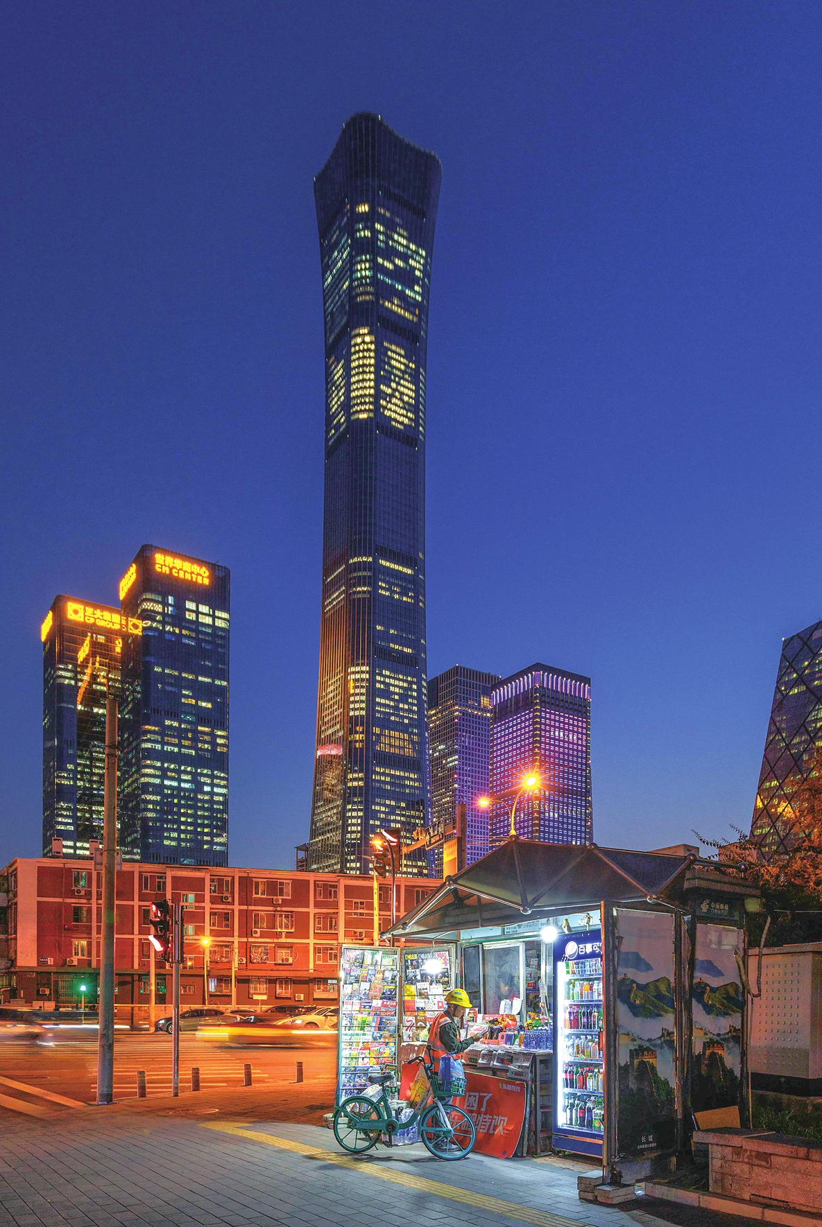 A migrant worker reads and buys newspapers at a newsstand in the Beijing Central Business District on October 21, 2025. Photo: VCG