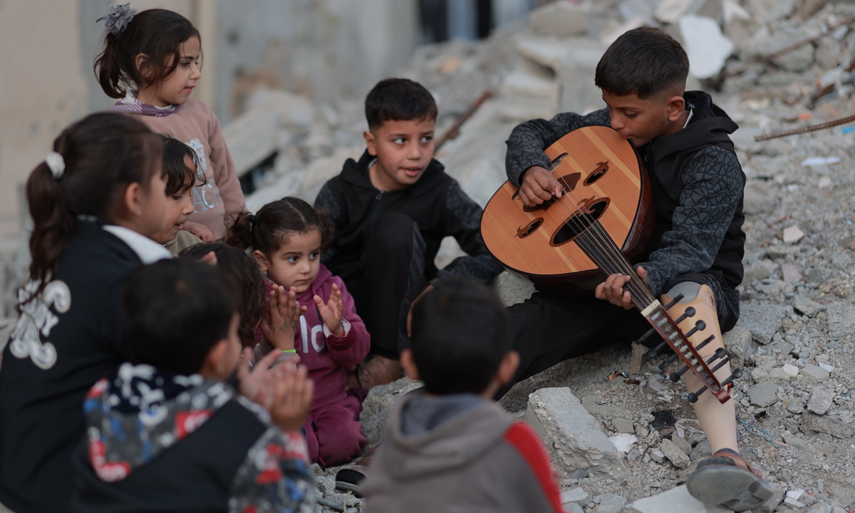 Twelve-year-old Abdurrahman al-Nashash, who lost his father and his left leg in an Israeli army attack targeting al-Razi School in Gaza, plays his oud at Bureij camp in Deir al-Balah, Gaza on January 29, 2026. Photo: VCG