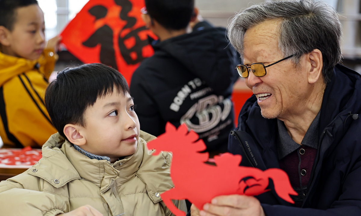 A retired man teaches children papercutting, which can be used as Spring Festival decorations, at a local community activity center as part of a winter vacation care center program on February 4, 2026 in Lanzhou, Northwest China's Gansu Province. Photo: VCG
