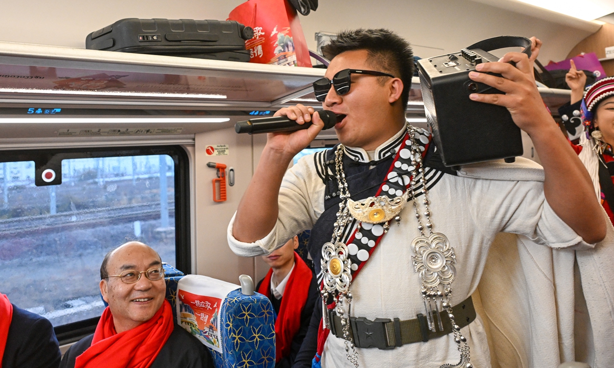 A member of the Kunming Dage Team, carrying a portable speaker on his shoulder, performs onboard a China-Laos Railway train as part of activities to celebrate the upcoming Spring Festival on February 4, 2026. Dage, a traditional folk art of the Yi ethnic group usually performed during festivals, weddings, funerals and other gatherings, has a history of about 10 centuries and was listed as a national-level intangible cultural heritage in 2008. Photo: VCG