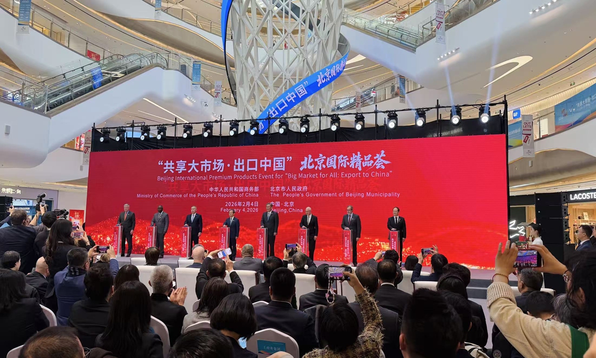 Chinese Minister of Commerce Wang Wentao (center) and ambassadors to China from multiple countries press the launch button for the 