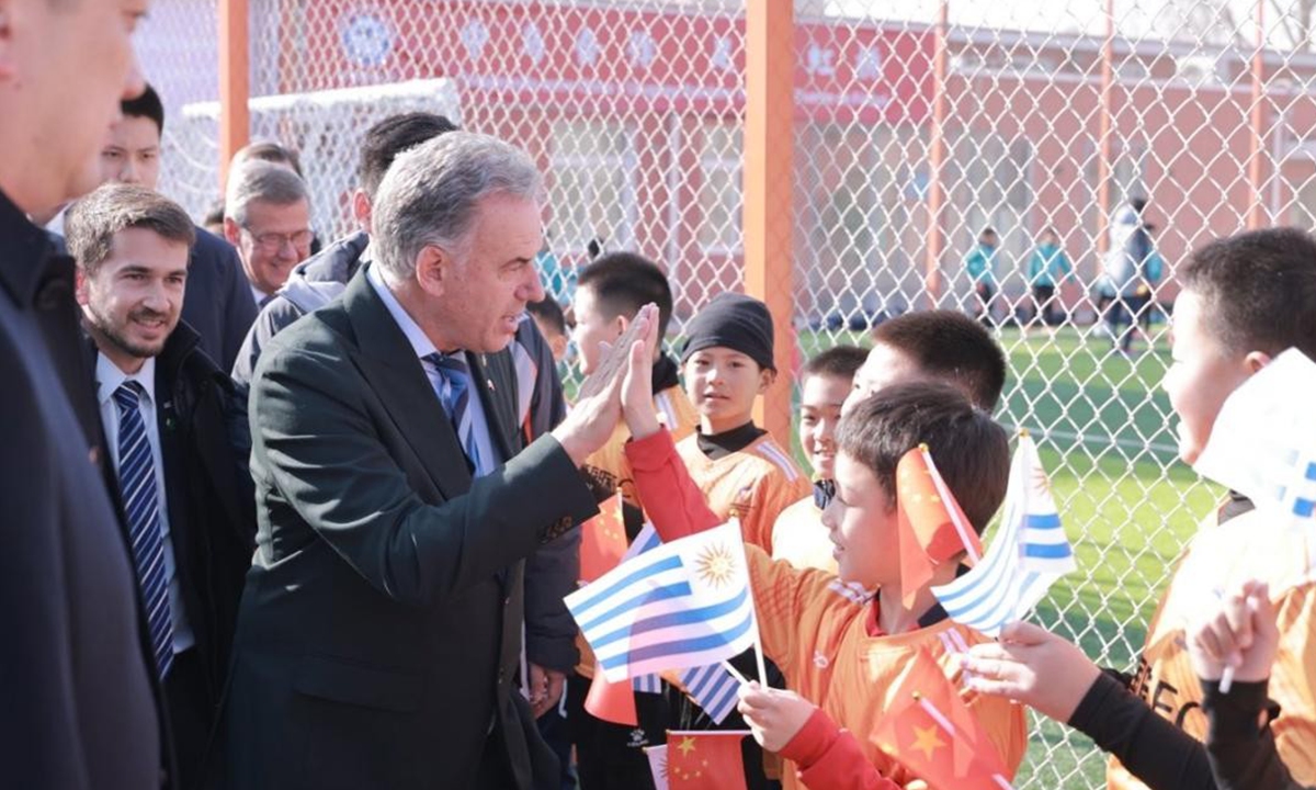 Uruguayan President Orsi high-fives young players at the China Rainbow International Football Club in Beijing on February 4. Photo: Courtesy of China Rainbow Inter FC