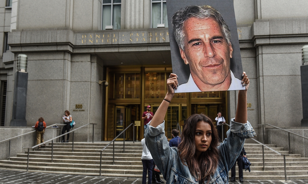 A woman holds up signs of Jeffrey Epstein and protests in front of the federal courthouse on July 8, 2019 in New York City. Photo: VCG