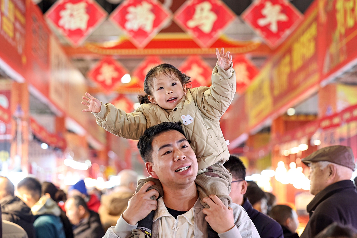 A father and daughter explore a fair featuring Chinese New Year goods. Photo: VCG