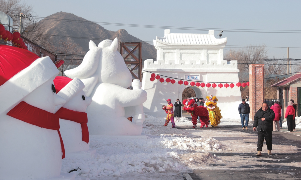 Lion dancers prepare for a performance to celebrate Xiaonian (Little New Year) at the foot of the Great Wall in the Yanqing district, Beijing, on February 10, 2026. Photo: VCG