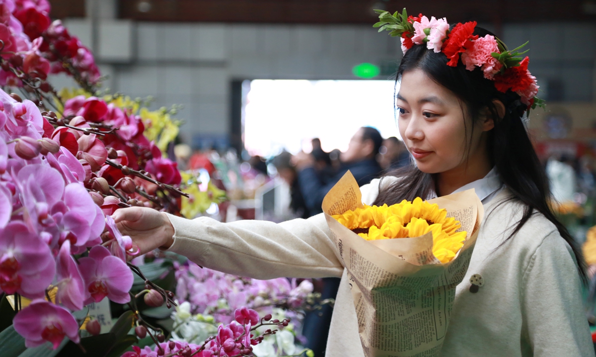 A woman checks out flowers at the Dounan flower market, in Kunming, Southwest China's Yunnan Province. Photo: VCG