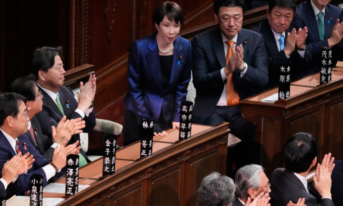 Members of the lower house of Japan's parliament applaud as Sanae Takaichi, standing, was reelected as prime minister during a special session in Tokyo, Japan, February 18, 2026. Photo: VCG