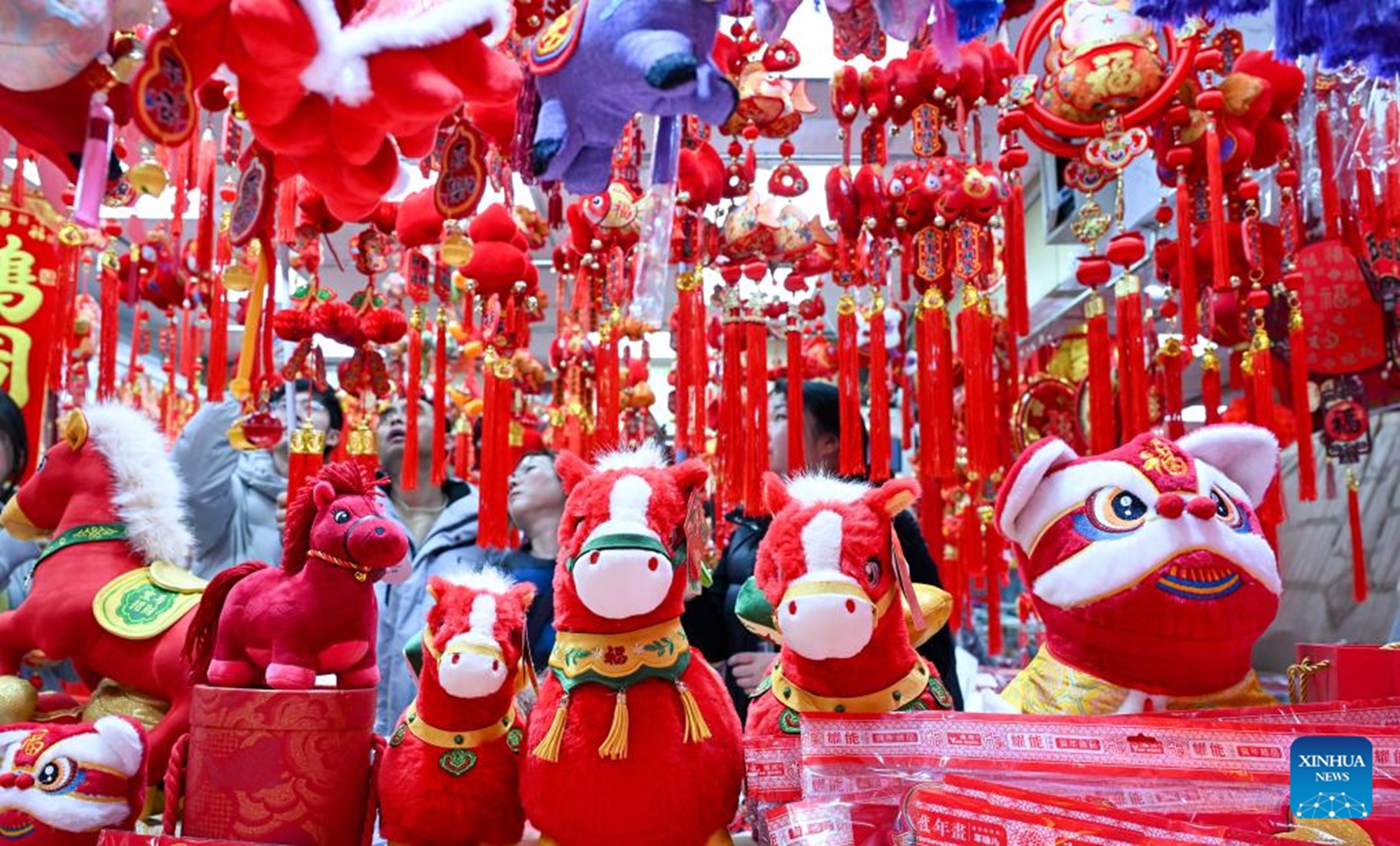 People shop for Chinese New Year decorations at a market in Nanjing, east China's Jiangsu Province, Feb. 13, 2026. Markets across the country are bustling nowadays as people flock there to stock up on goods in preparation for the upcoming Spring Festival, or the Chinese New Year. (Photo by Yang Suping/Xinhua)

