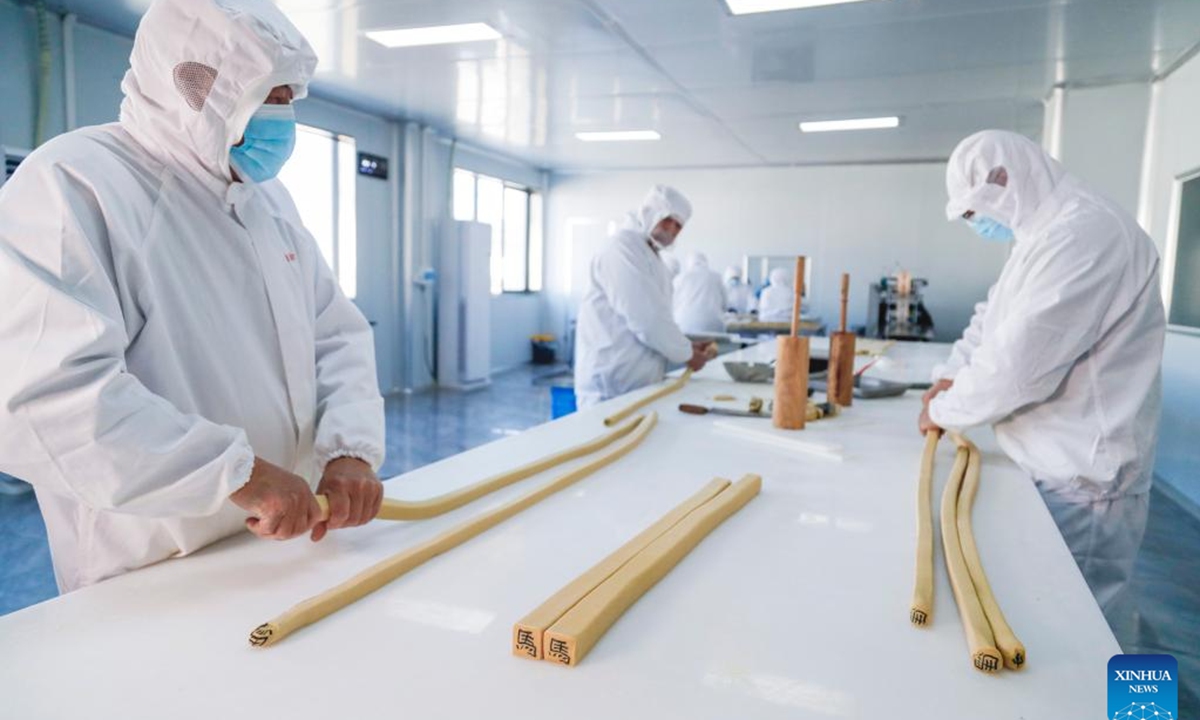 Staff members make character-inlaid candies in Qimen County of Huangshan City, east China's Anhui Province, Jan. 13, 2026.