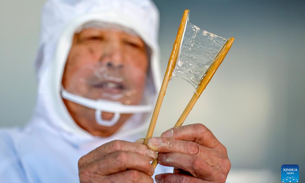 A staff member makes character-inlaid candies in Qimen County of Huangshan City, east China's Anhui Province, Jan. 13, 2026.