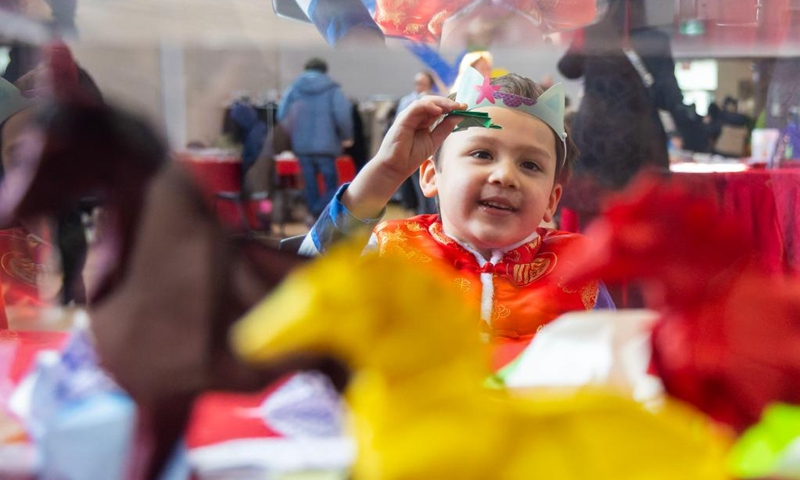 A boy in traditional Chinese costumes displays his origami frog in celebration of Chinese New Year at the Chinese Cultural Center of Greater Toronto in Toronto, Canada, Feb. 15, 2026. (Photo by Zou Zheng/Xinhua)