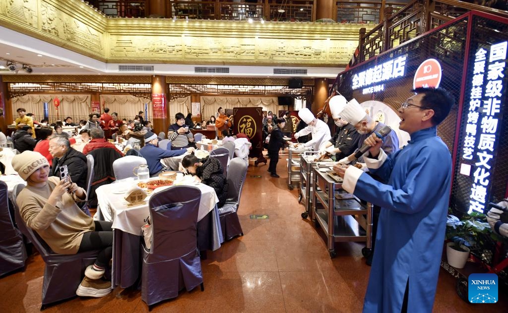 A staff member briefs diners about the history of Beijing Roast Duck, also known as Peking Duck, at the Qianmen branch of Quanjude, one of China's best-known roast duck chain store brands, in Beijing, capital of China, Feb. 16, 2026. Chinese New Year's Eve is the most significant moment of Spring Festival celebrations when families and friends sit around the table to share delicious food and personal stories, and stay up to welcome the New Year. (Photo: Xinhua)