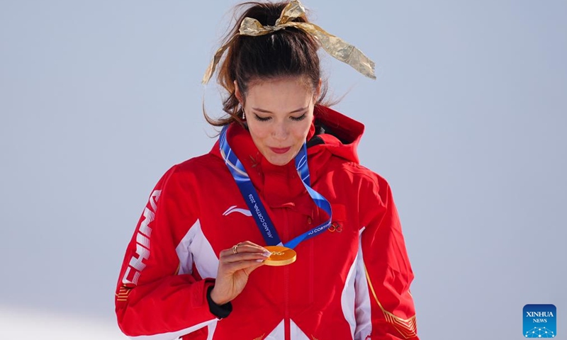 Gold medalist Gu Ailing of China looks at her medal during the awarding ceremony for freestyle skiing women's freeski halfpipe at the Milan-Cortina 2026 Olympic Winter Games in Livigno, Italy, Feb. 22, 2026. (Xinhua/Hu Chao)