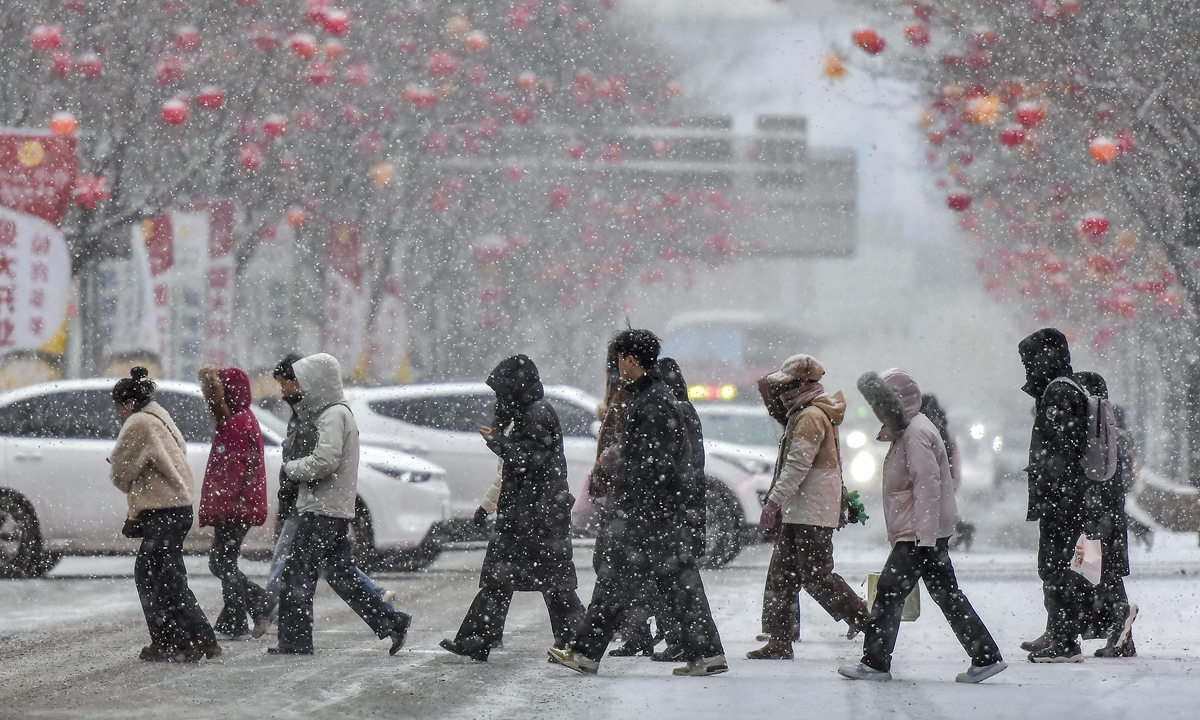 Residents venture out amid snowy weather in Urumqi, Northwest China's Xinjiang Uygur Autonomous Region, on February 24, 2026. Meteorological forecasts predict a sharp temperature drop across most of Xinjiang this week due to a strong cold air mass. The northern and eastern Altay prefecture will see a 12-16 C temperature drop, bringing an extreme cold wave. Photo: VCG