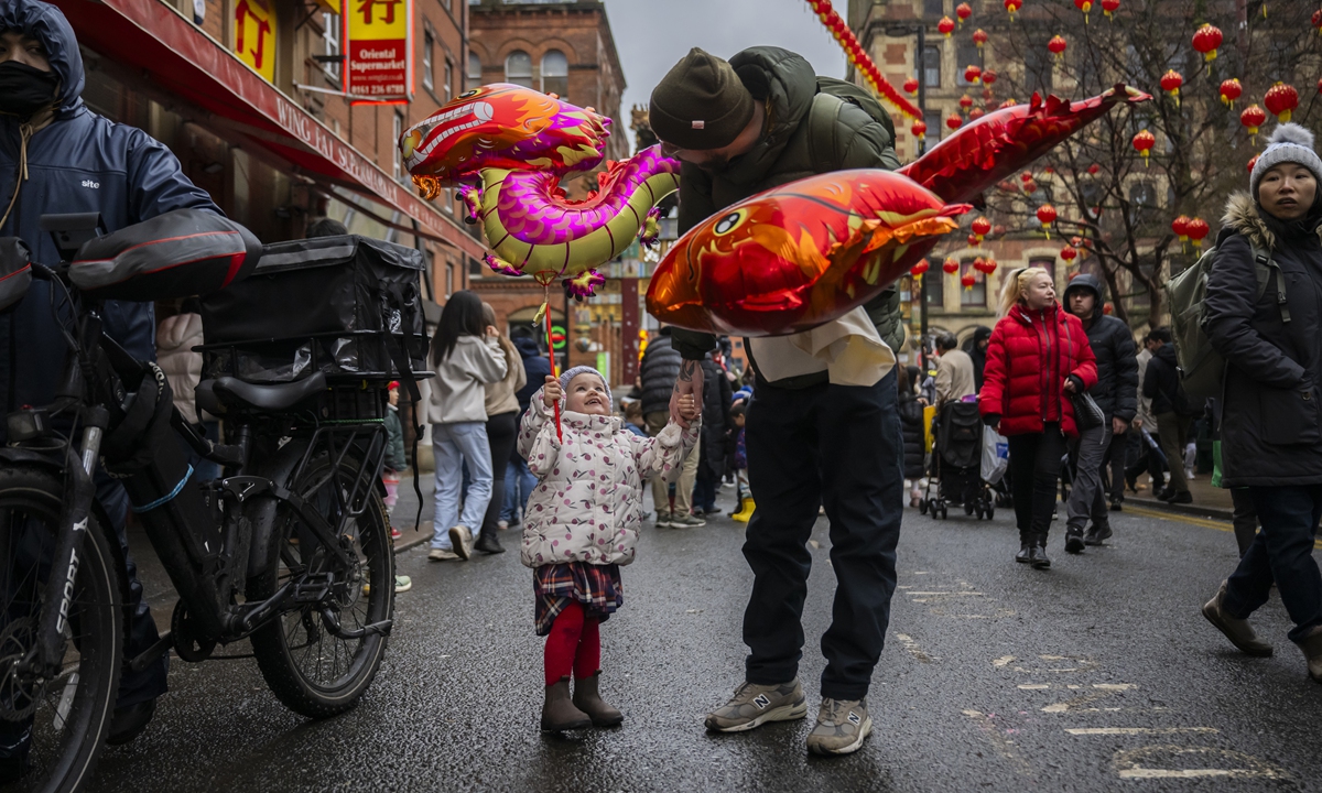 A little girl holds a balloon during the Chinese New Year celebration at Manchester Chinatown in Manchester, the UK, on February 15, 2026.