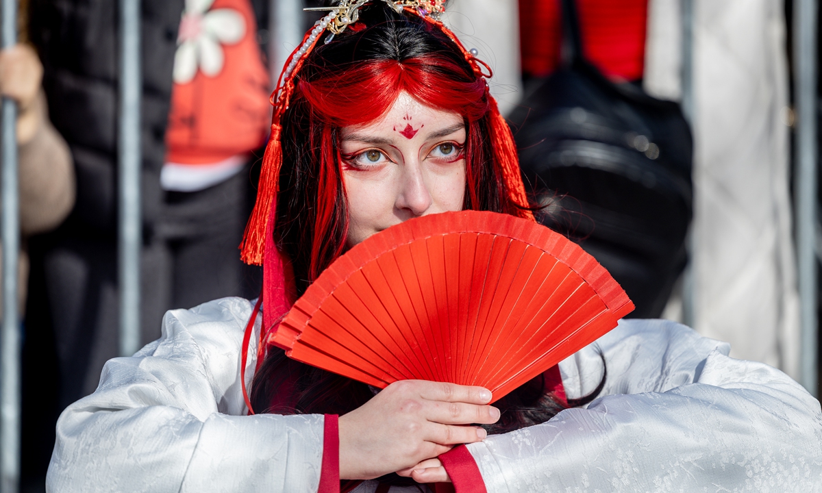 A participant dressed in clothing and accessories featuring Chinese elements joins a Spring Festival parade in Madrid, Spain, on February 22, 2026.