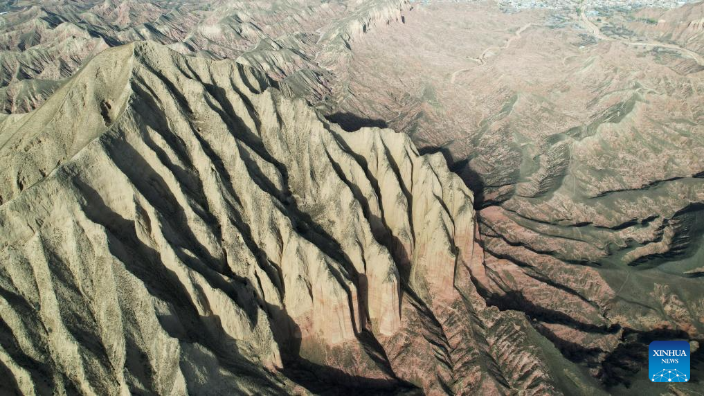 This aerial drone photo taken on April 4, 2026 shows a view of the Shilaquan Canyon in Tangwang Town of Dongxiang Autonomous County, Linxia Hui Autonomous Prefecture, northwest China's Gansu Province. Shilaquan Canyon has an average elevation of approximately 2,000 meters. The red sandstone and gravel layers on both sides of the canyon have been shaped by water erosion and wind abrasion, forming a distinctive Danxia landform. (Xinhua/Chen Bin)