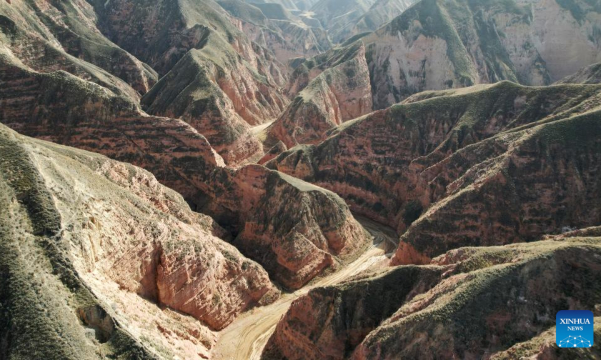 This aerial drone photo taken on April 4, 2026 shows a view of the Shilaquan Canyon in Tangwang Town of Dongxiang Autonomous County, Linxia Hui Autonomous Prefecture, northwest China's Gansu Province. Shilaquan Canyon has an average elevation of approximately 2,000 meters. The red sandstone and gravel layers on both sides of the canyon have been shaped by water erosion and wind abrasion, forming a distinctive Danxia landform. (Xinhua/Chen Bin)
