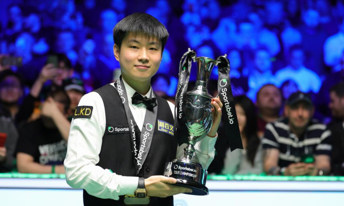 Zhao Xintong of China poses with his trophy during the awarding ceremony after the final between Zhao Xintong of China and Judd Trump of England at the 2026 Snooker Tour Championship in Manchester, Britain, on April 5, 2026. (Photo by Zhai Zheng/Xinhua)