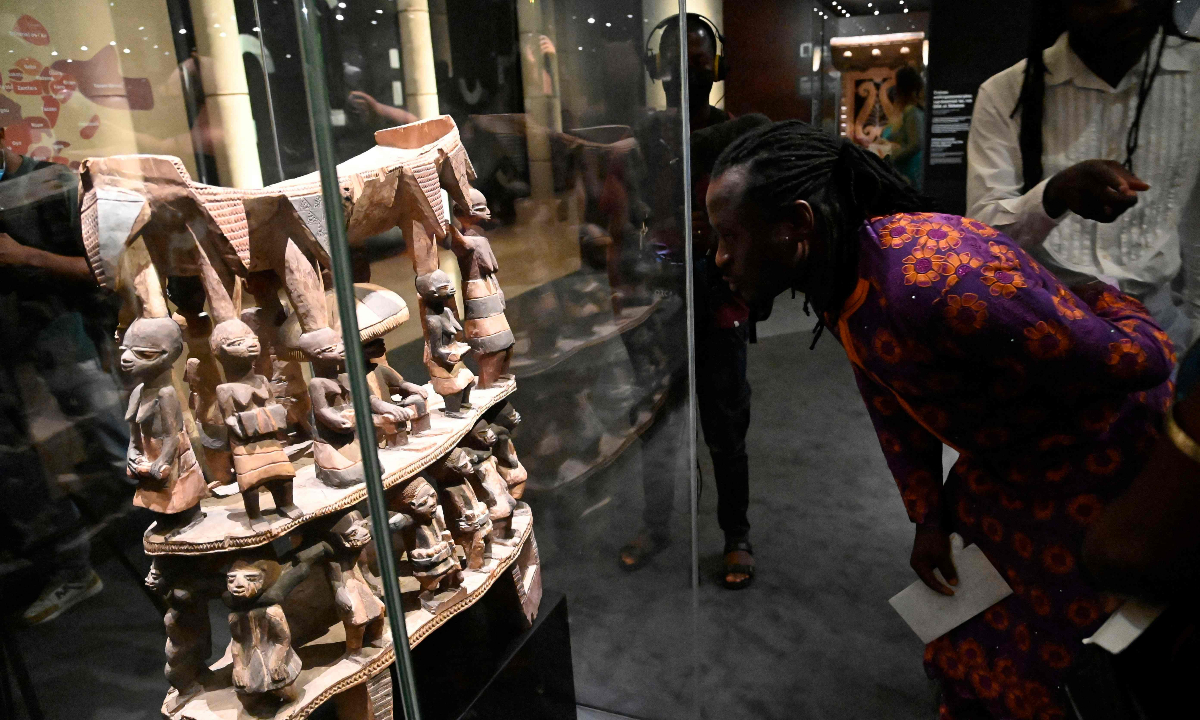A visitor examines the Cana throne, which was looted by French colonial soldiers, at an exhibition featuring both returned Benin artefacts and contemporary artworks in Cotonou, Benin, on February 18, 2022. Photo: VCG
